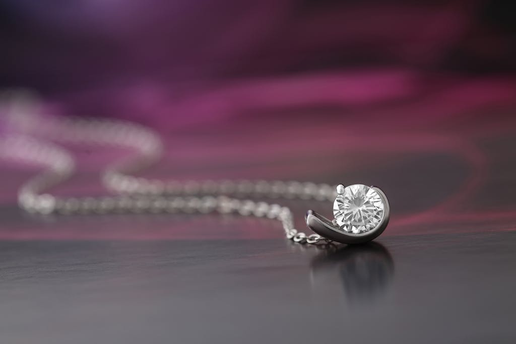 A close-up of a diamond necklace displayed against a soft, blurred background.